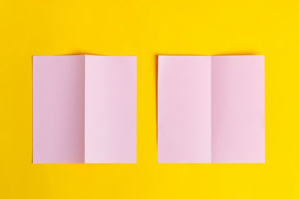 Bifold mock-up pink paper brochures on a yellow background