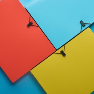 top view of arranged colorful paper folders on blue